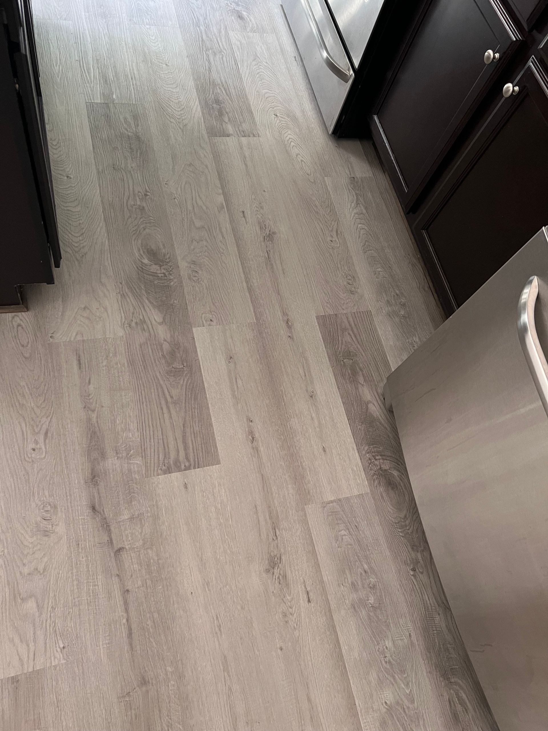 A kitchen with hardwood floors and stainless steel appliances.