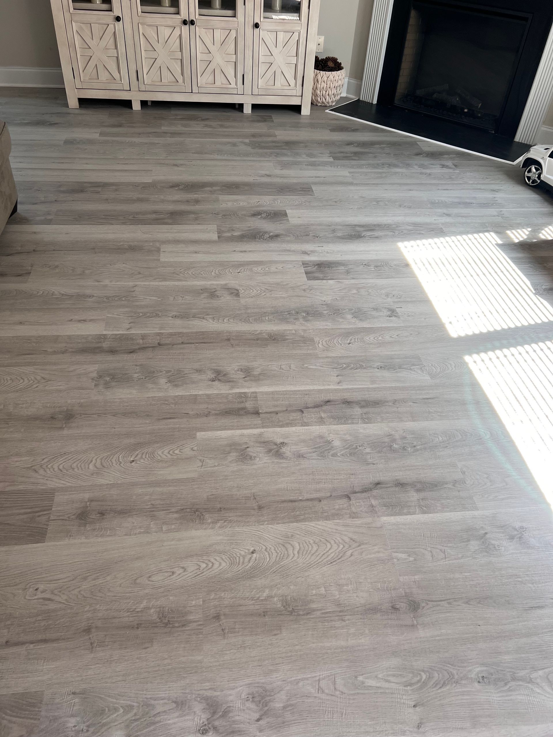 A living room with hardwood floors and a fireplace.
