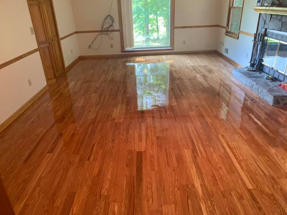 A living room with hardwood floors and a fireplace.