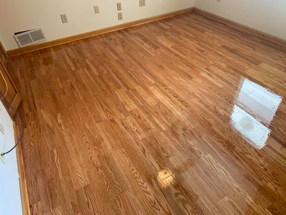 A room with a wooden floor and a white wall.