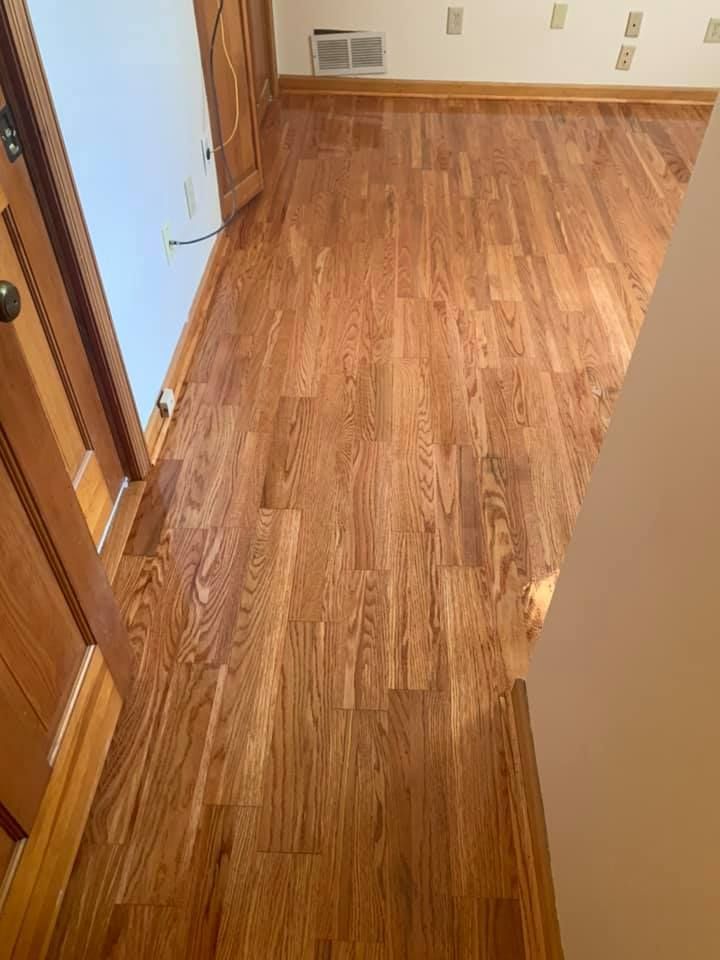 A room with hardwood floors and a white wall.