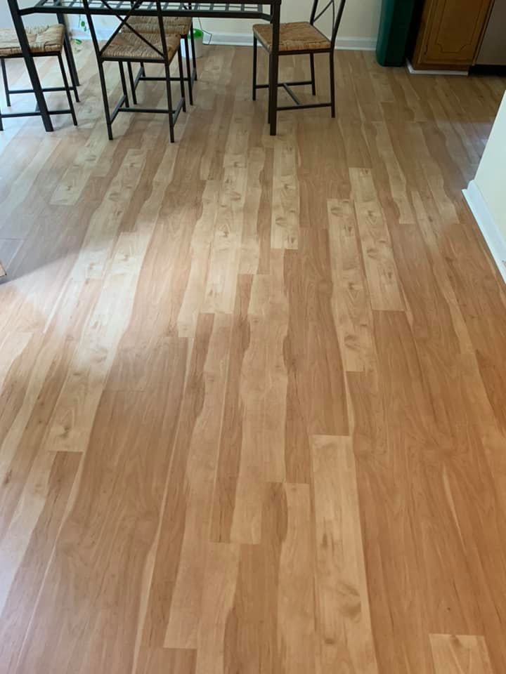 A wooden floor in a dining room with a table and chairs.