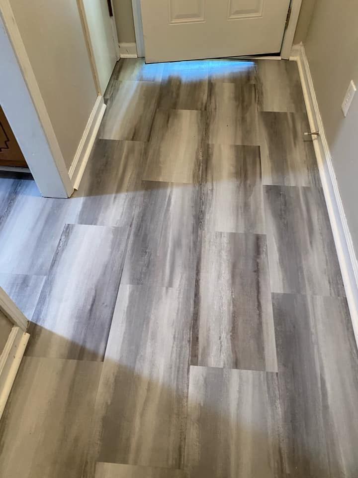 A hallway with a wooden floor and a door.