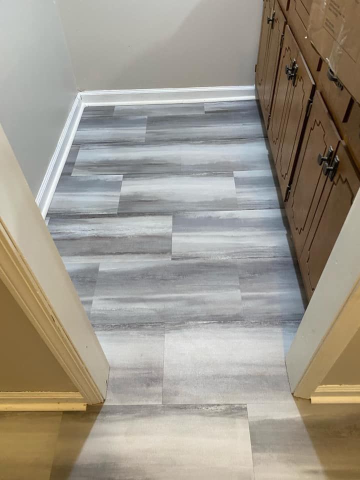 A bathroom with a wooden floor and cabinets.