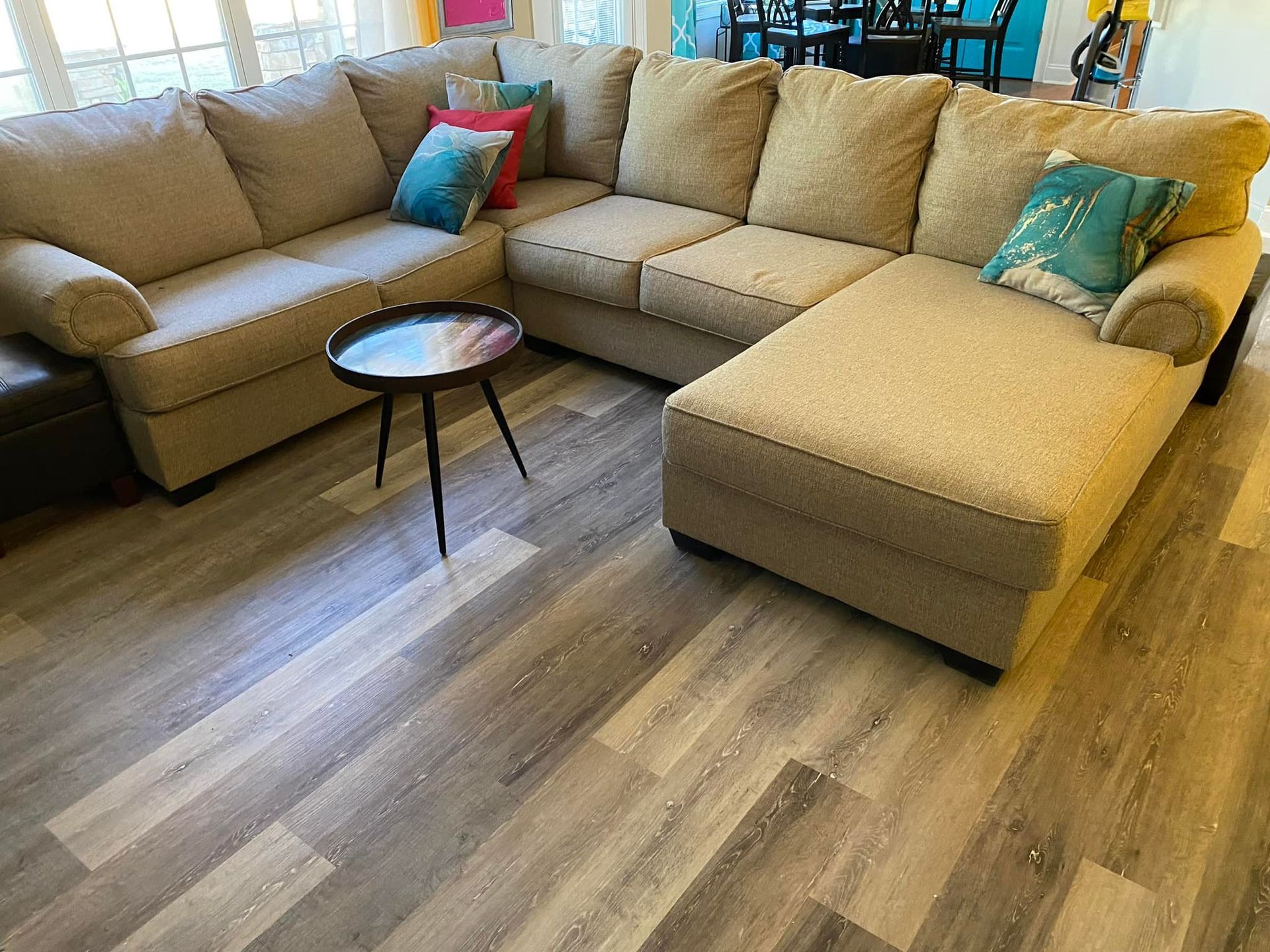 A living room with a large sectional couch and a small table.