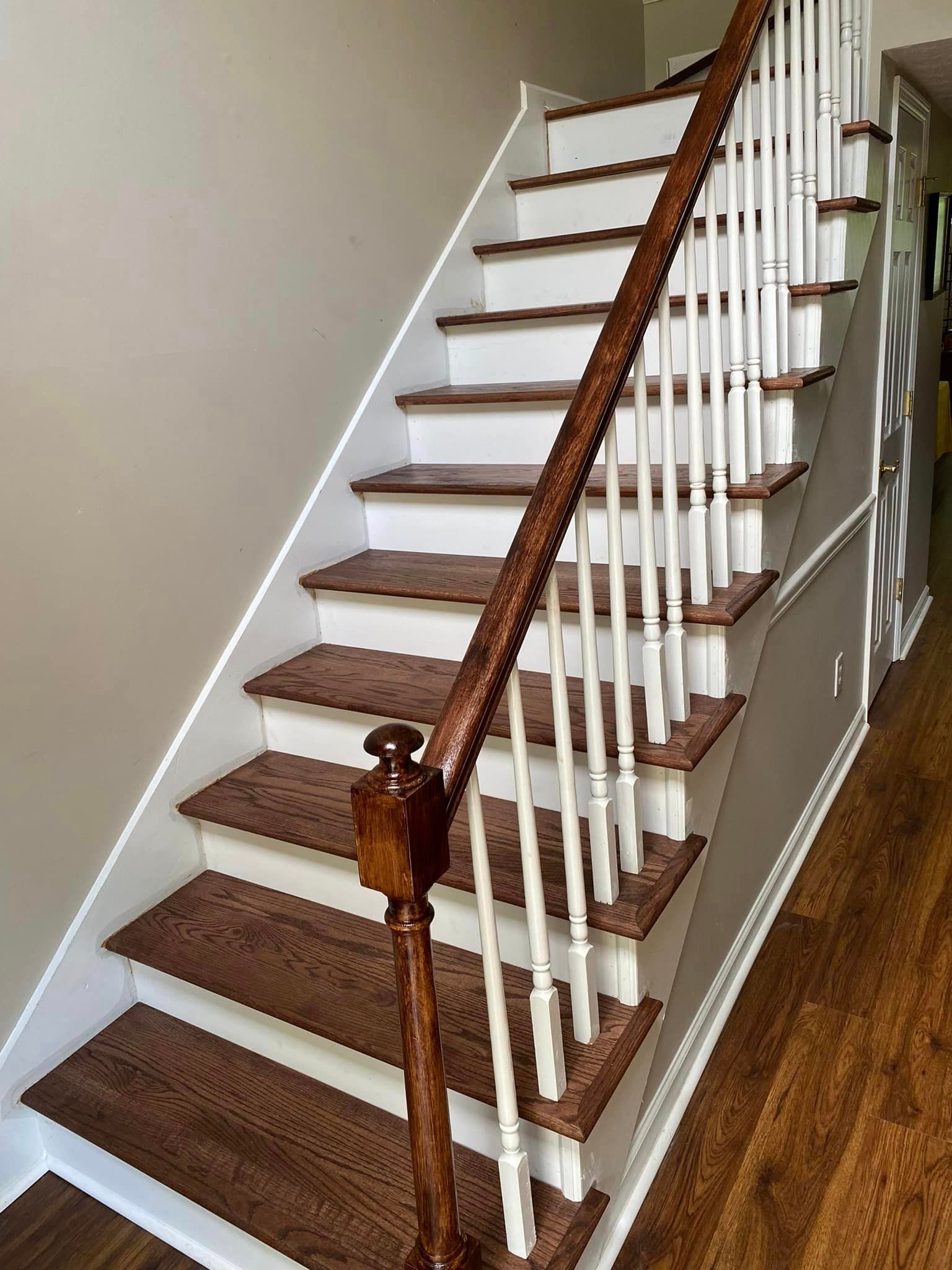 A staircase with wooden steps and white railings in a house.