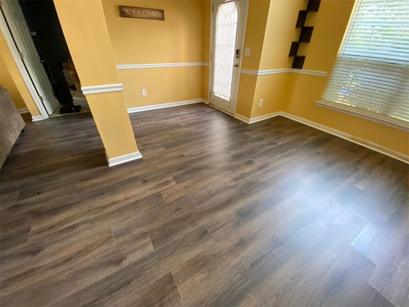 A living room with hardwood floors and yellow walls.