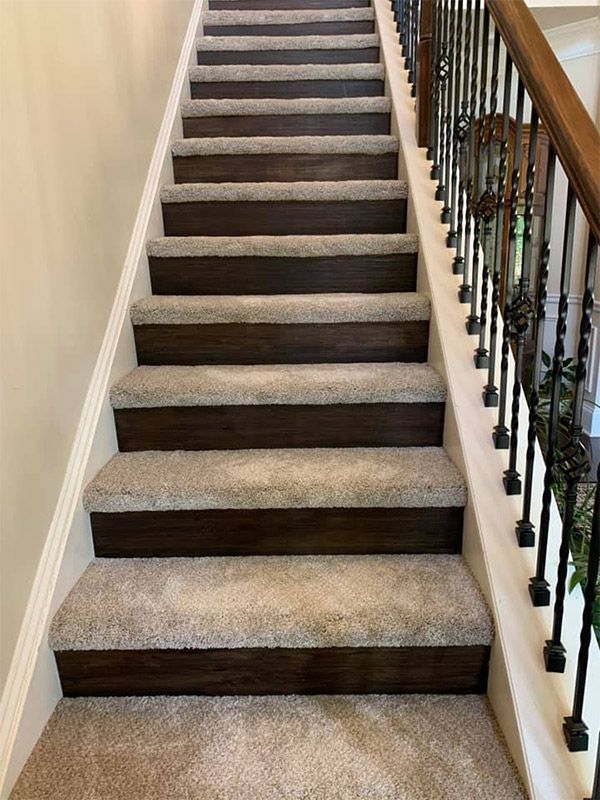 A set of stairs with carpet and wooden steps in a house.