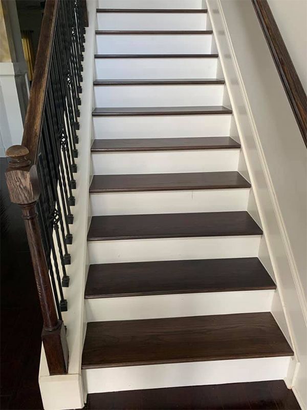 A staircase with white steps and wooden steps in a house.