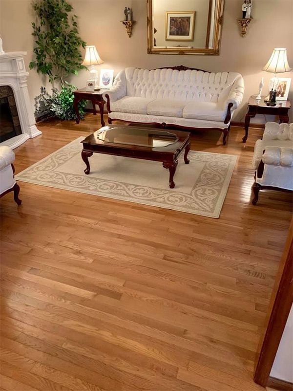 A living room with hardwood floors a couch a coffee table and a fireplace