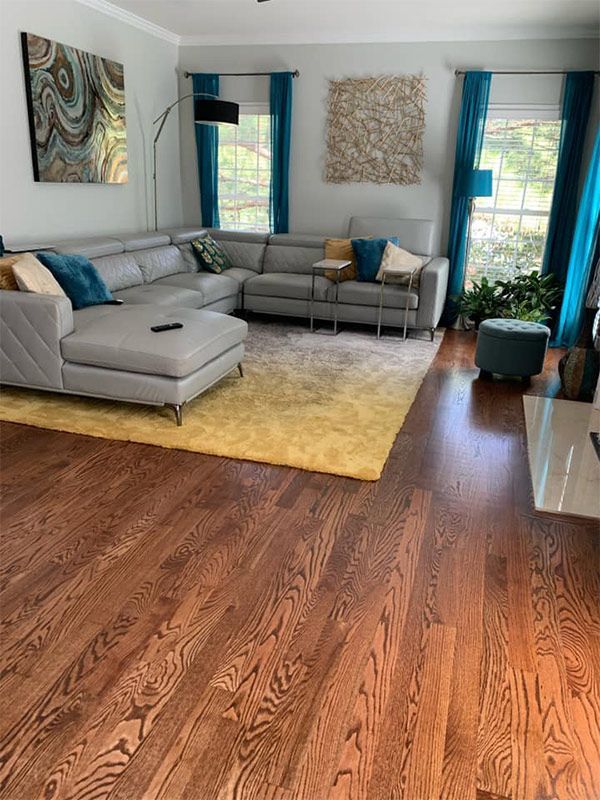 A living room with hardwood floors and a sectional couch.