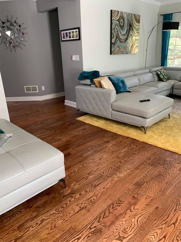 A living room with hardwood floors and a sectional couch.