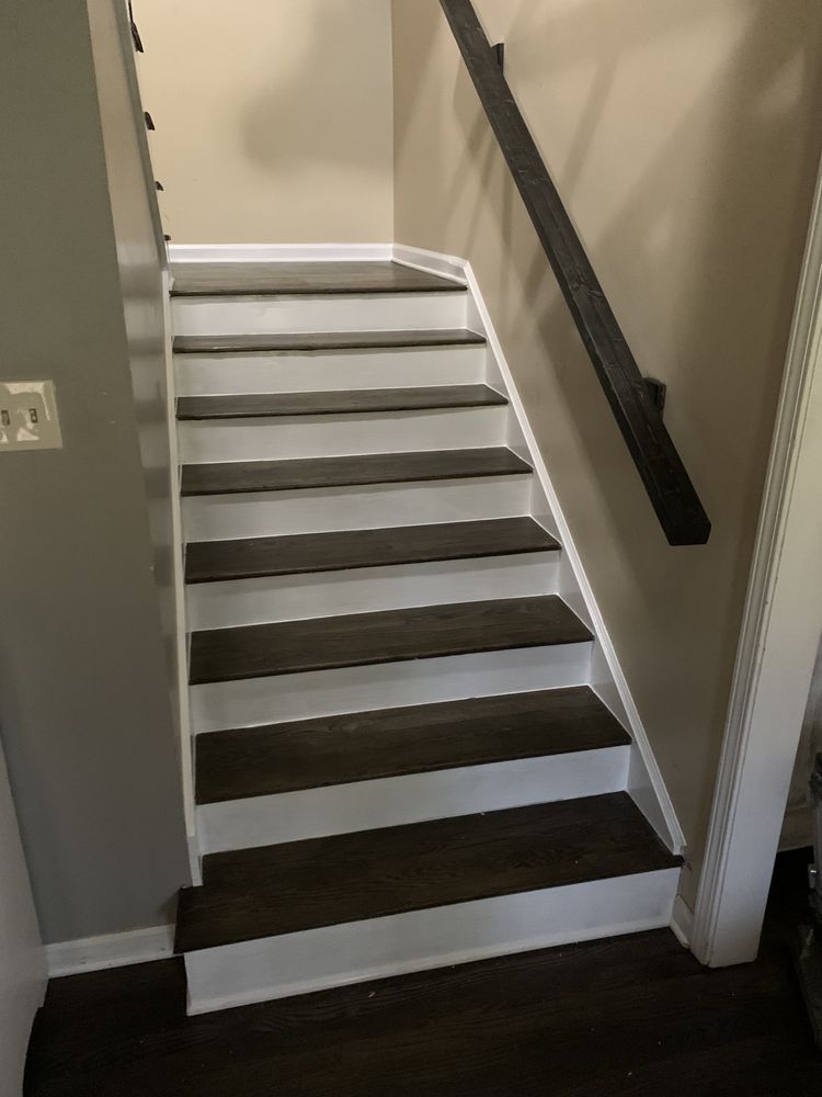 A set of stairs with wooden steps and a white railing.