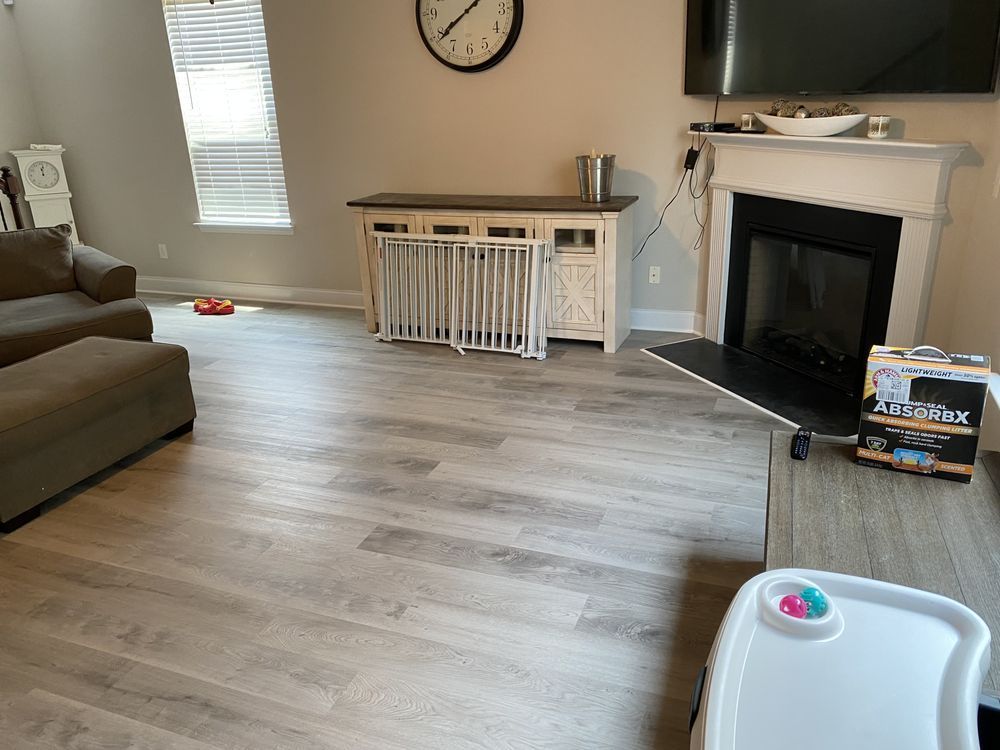 A living room with a fireplace and a clock on the wall.