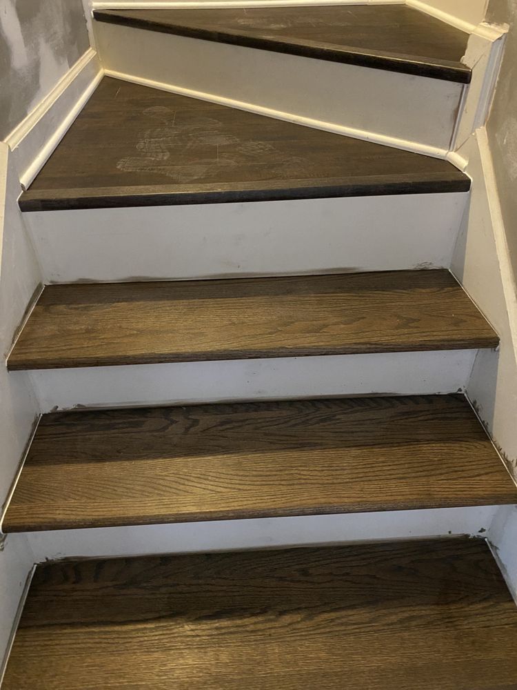 A set of stairs with wooden steps and a white railing.