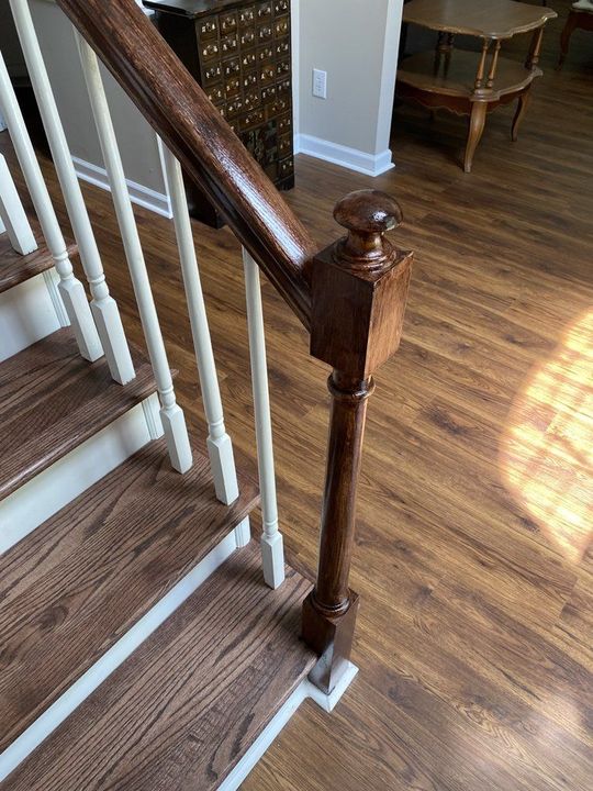 A staircase with a wooden railing and carpeted steps