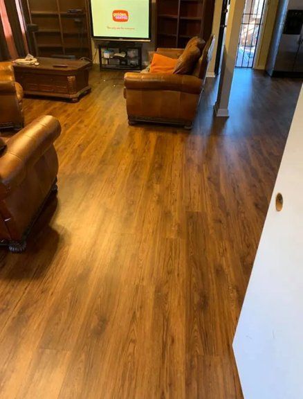 A living room with hardwood floors and a couch and chairs