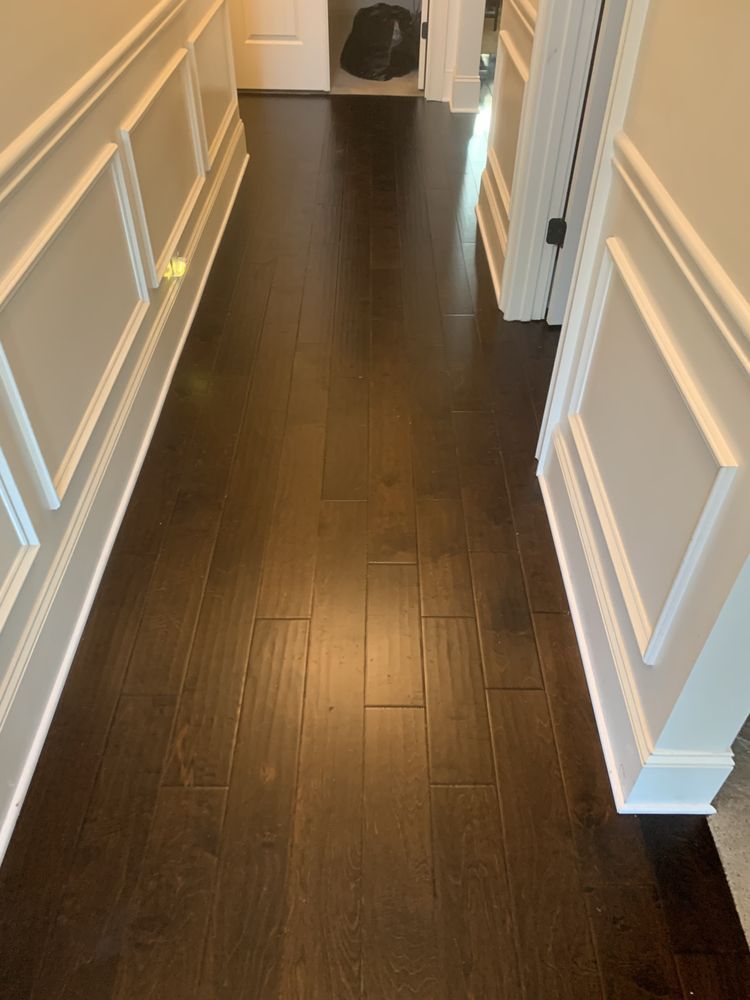 A hallway with hardwood floors and white trim