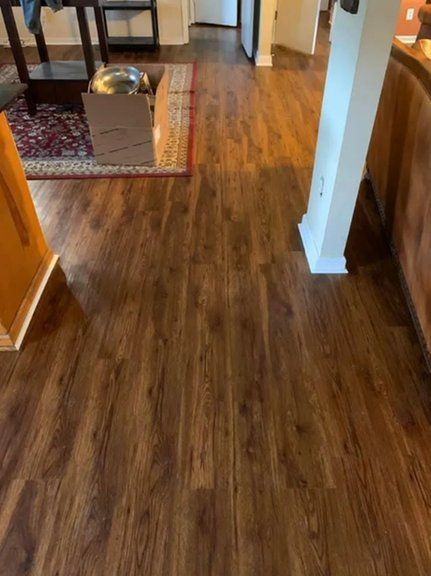 A living room with hardwood floors and a box on the floor.