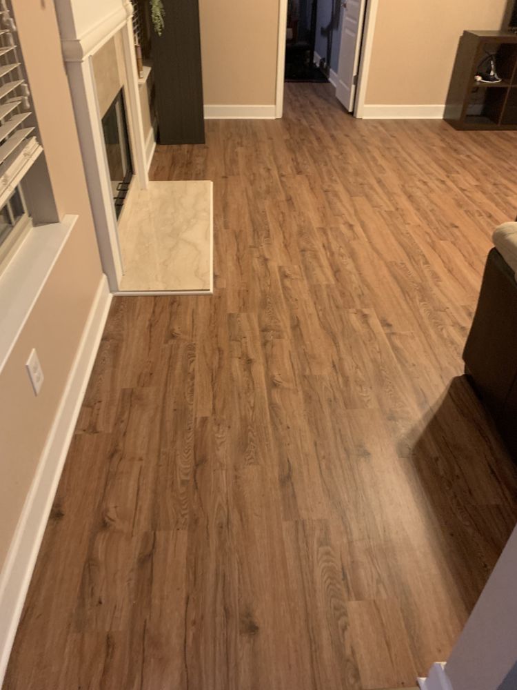 A living room with hardwood floors and a fireplace.