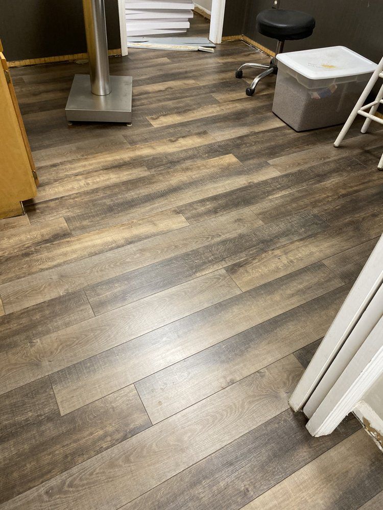 A room with a wooden floor and a stool.