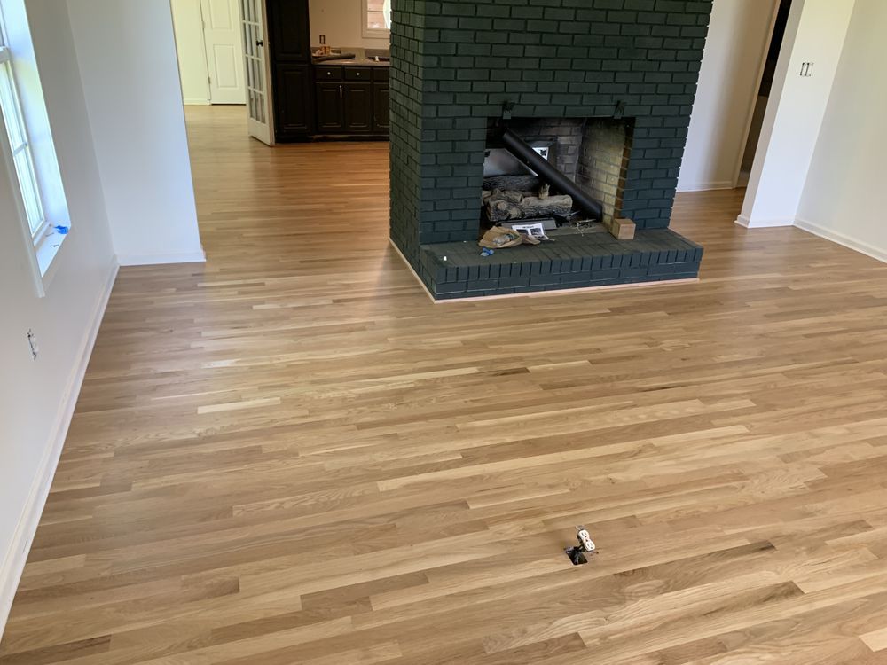 A living room with hardwood floors and a fireplace.