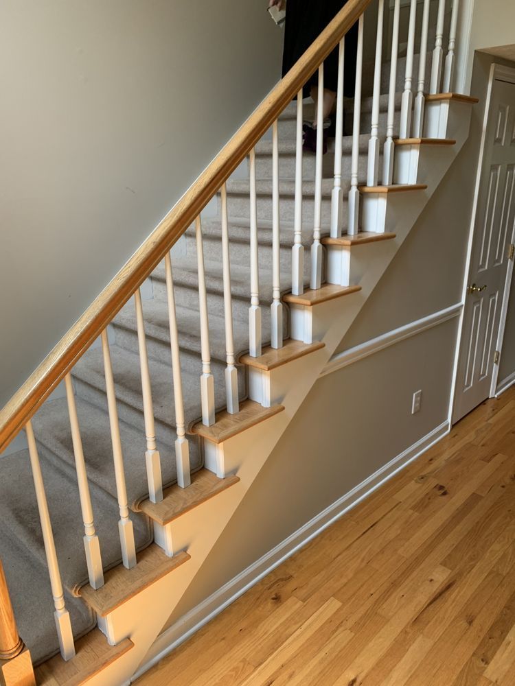 A staircase with a wooden railing and carpeted steps