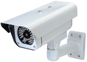 A white security camera is mounted to a wall