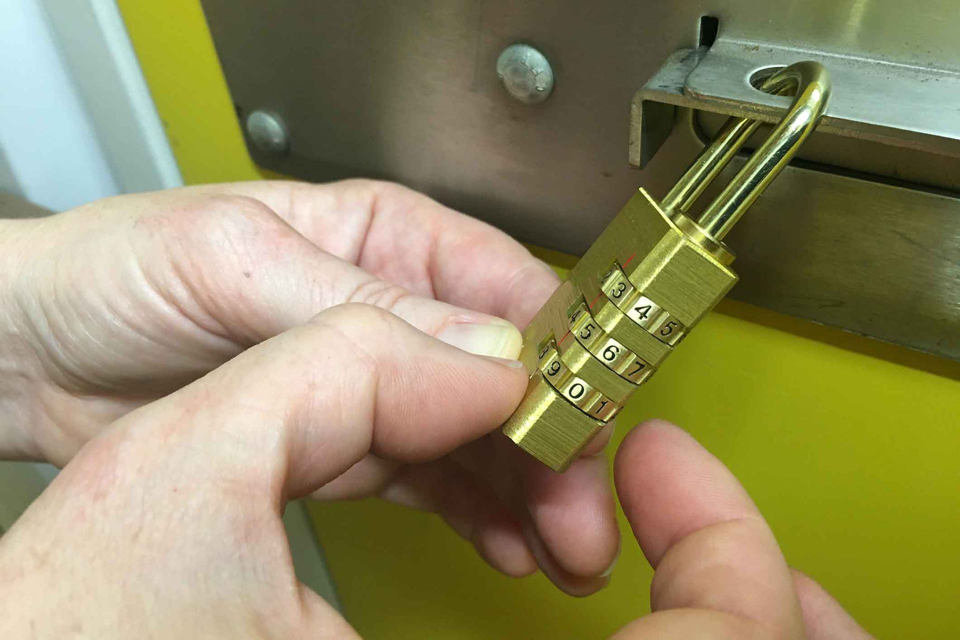 A person is holding a combination lock in their hands.