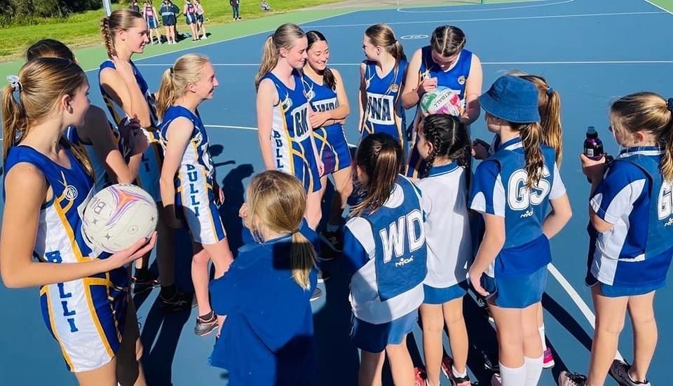 Blue Printed Jersey Wearing Volleyball Players Gathering For Team Huddle — Promotional Apparel In Kiama, NSW