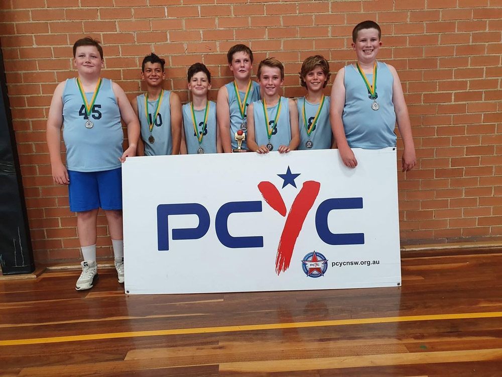 Kids Wearing Basketball Uniforms With Medals — Promotional Apparel In Woonona, NSW