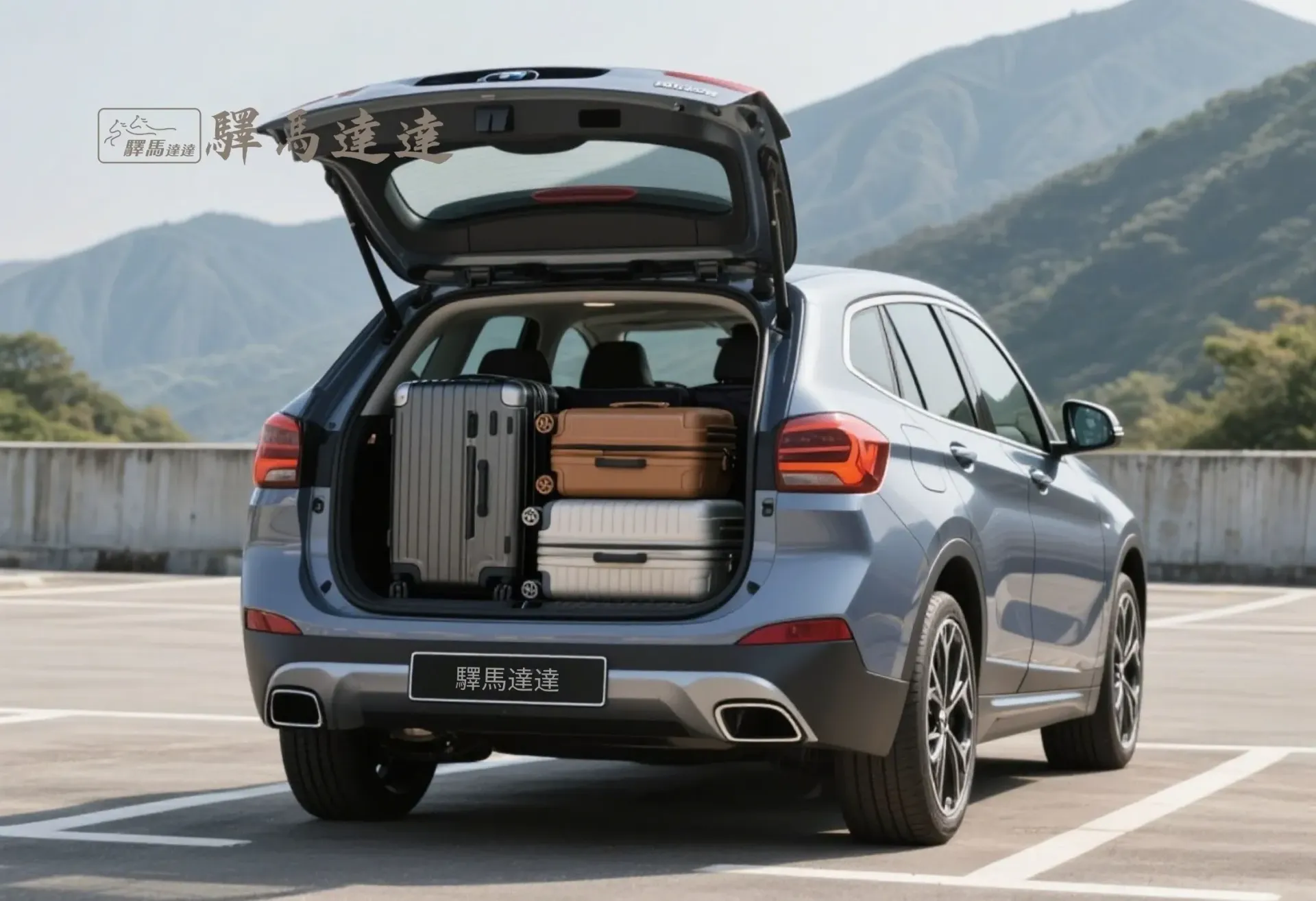 寶馬iX1 後車廂滿載視角圖,行李區整齊擺放 3 個登機與托運行李箱(以 28 吋和 20 吋為主),展現高效裝載能力。背景為台灣山腳下的停車場,畫面左上角顯示「驛馬達達」標誌。