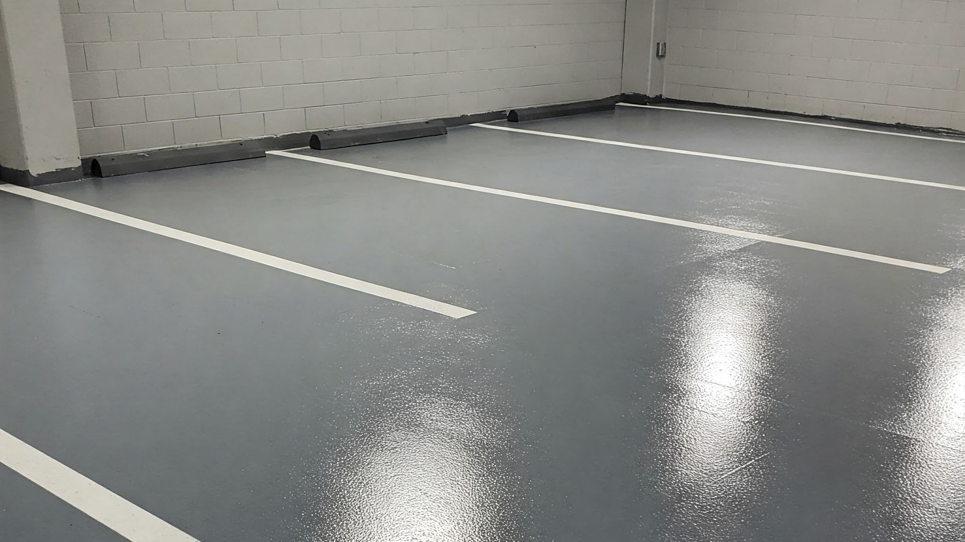 An epoxy flooring applied in a parking garage with a lot of parking spaces.