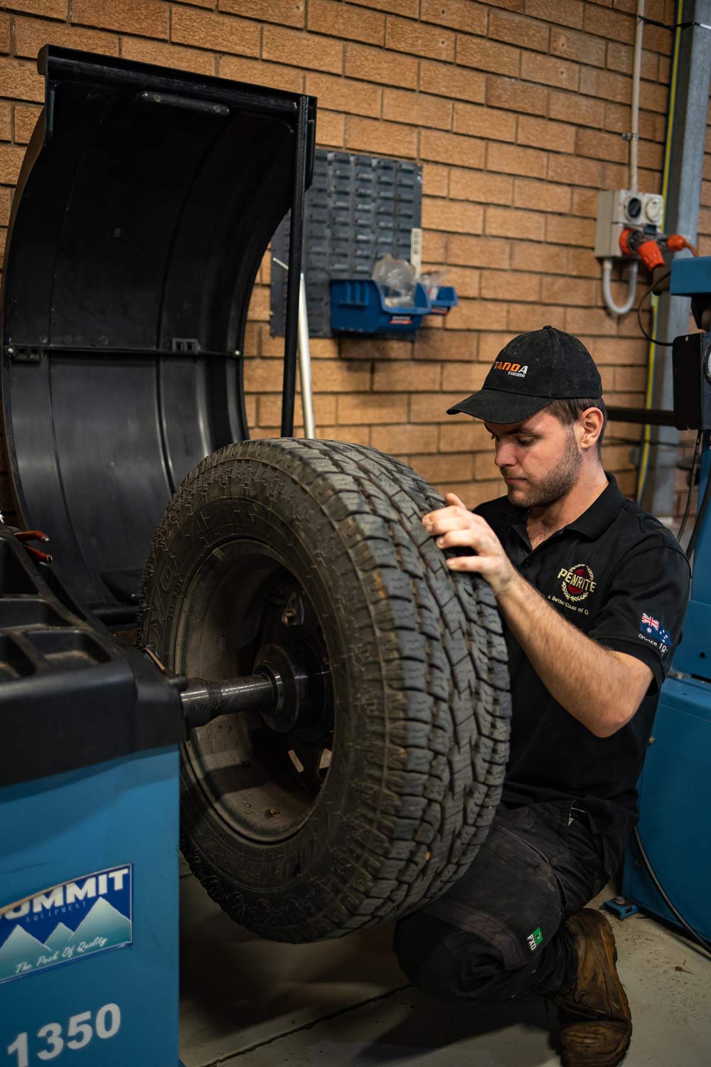 Man Pressing Tire Using Machine — Stock & Fit Car Tyres in Dubbo, NSW