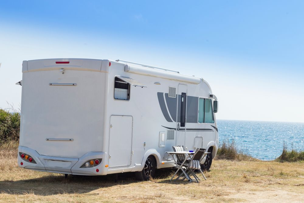 A Caravan is parked on sand in front of the ocean— Goulburn Transport In Goulburn, NSW