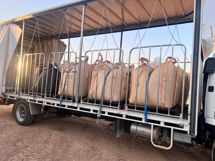 A Truck Filled With Bags of Sand is Parked in the Dirt — Goulburn Transport In Goulburn, NSW