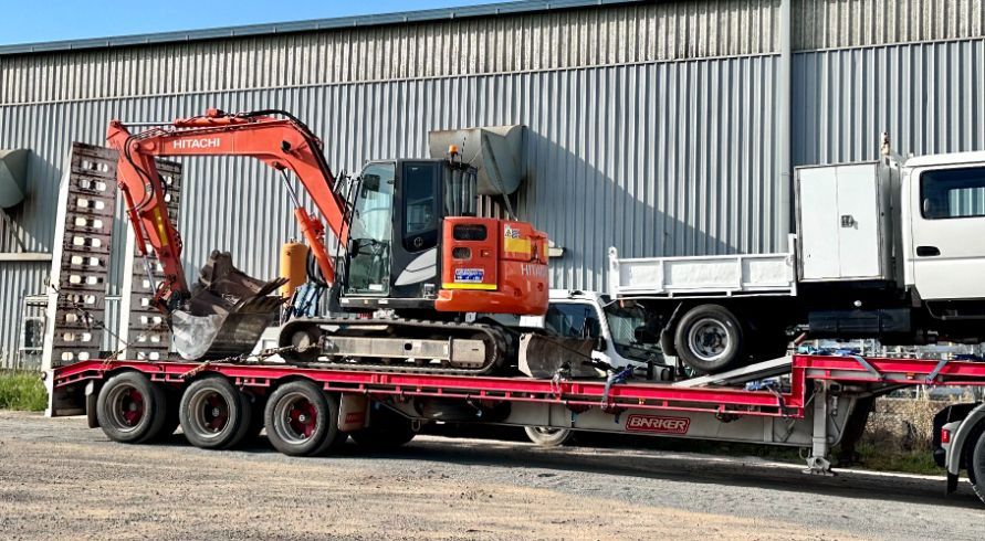 A Red Excavator and white truck are on a Trailer — Goulburn Transport In Goulburn, NSW