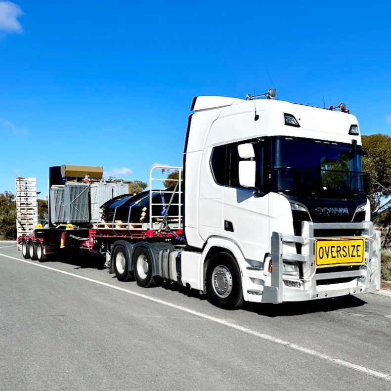 A White Truck With a Yellow Sign on the Front That Says Oversize — Goulburn Transport In Goulburn, NSW