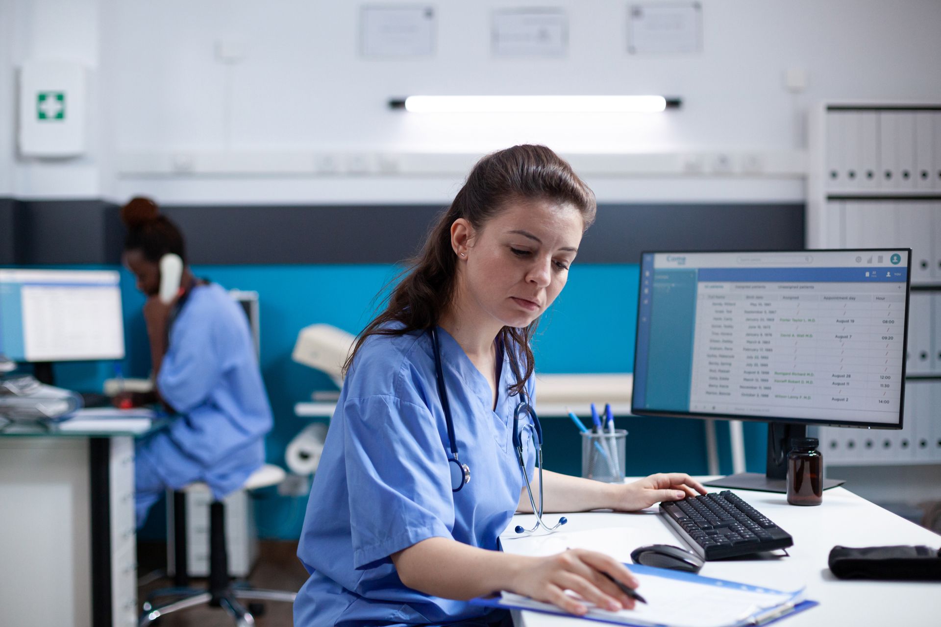 nurse on-duty entering data from a clipboard on a computer for r2v3 standard 