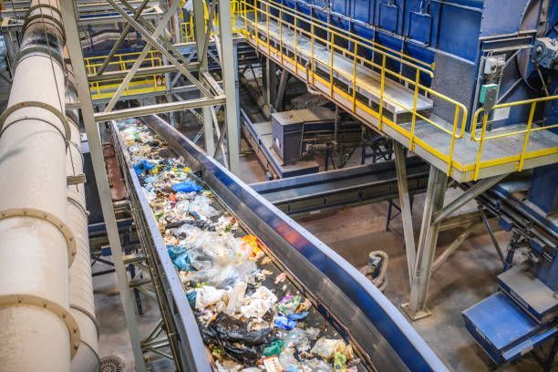 A conveyor belt filled with trash in a factory in a modern recycling facility