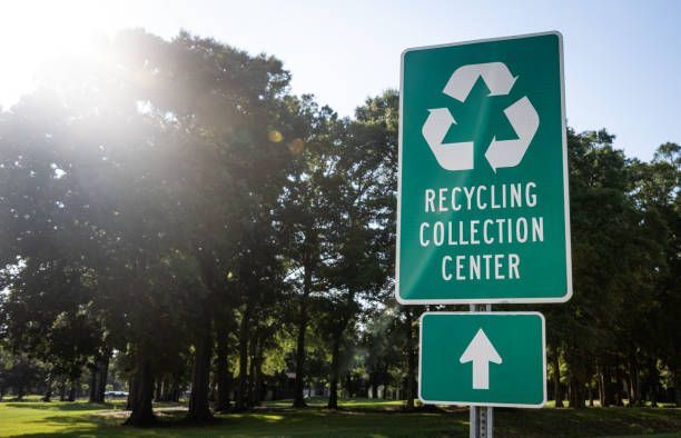 A green sign that says recycling center on it.