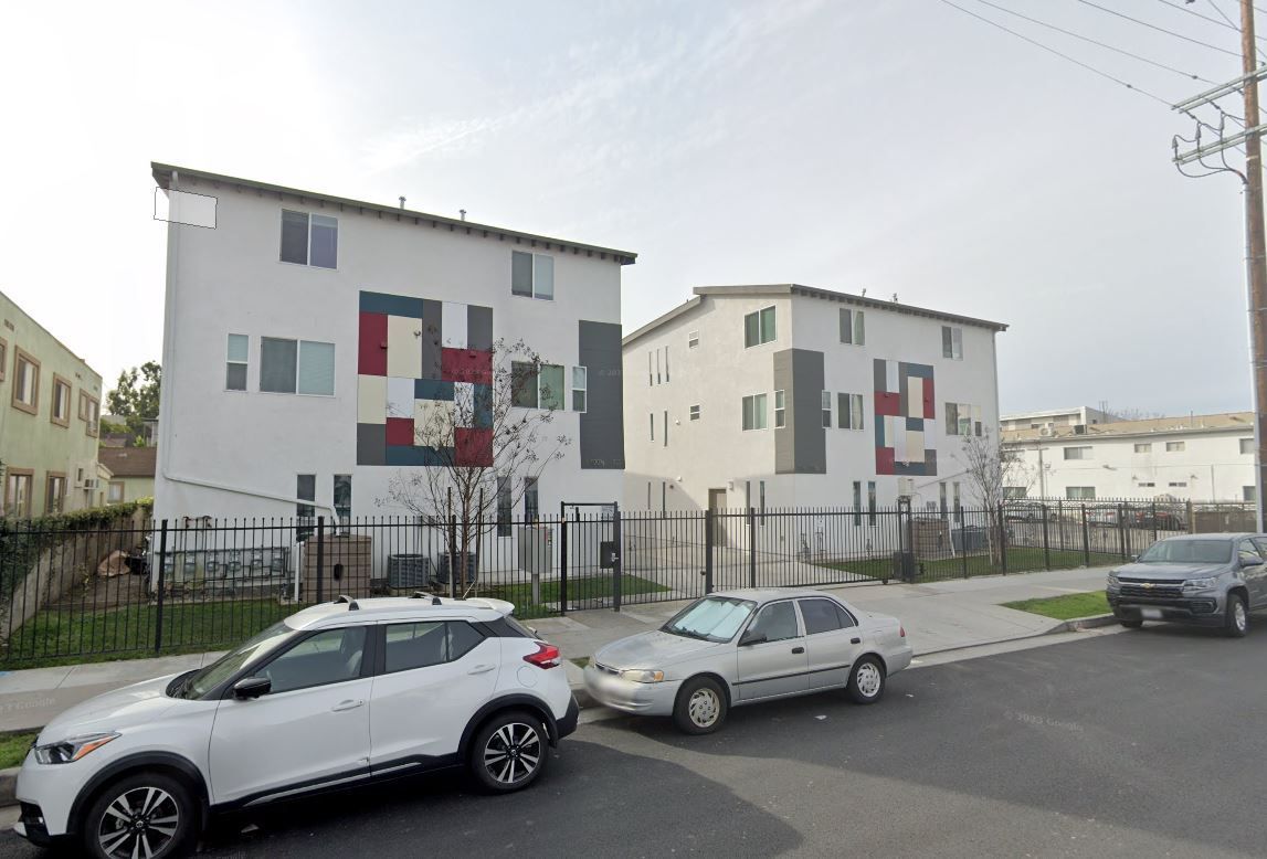 A couple of cars are parked in front of a building.