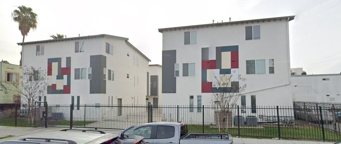 A couple of buildings with cars parked in front of them.