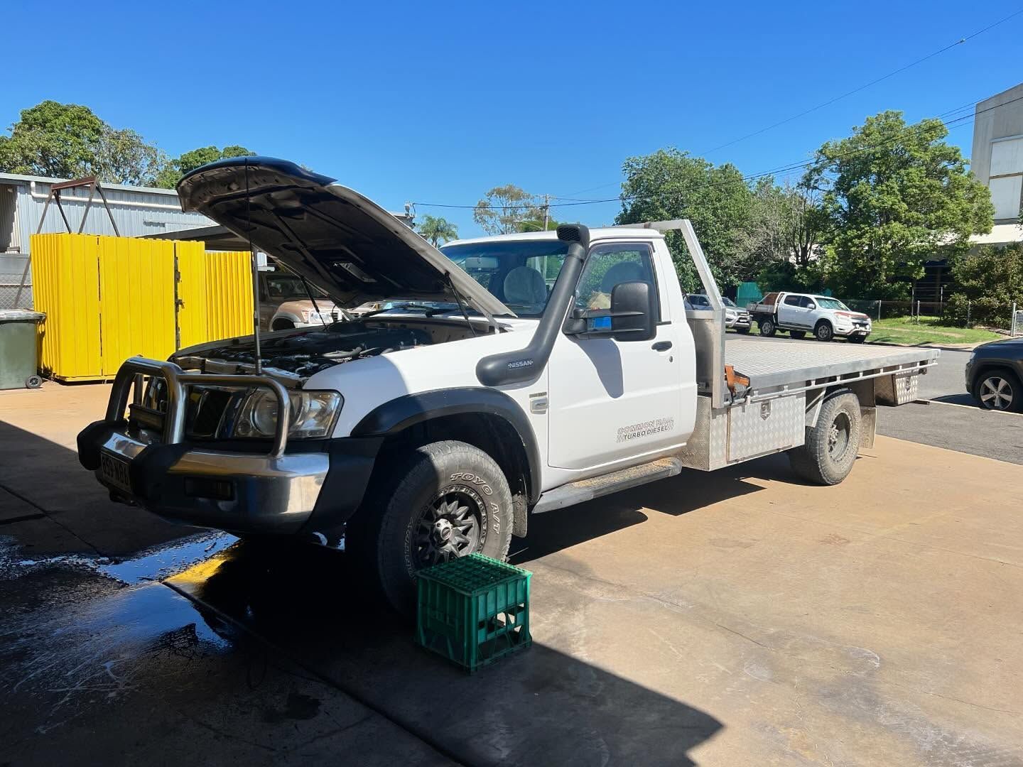 White pickup truck with hood up, on a concrete driveway, water on the ground— Bundaberg Radiator Service in Bundaberg East, QLD