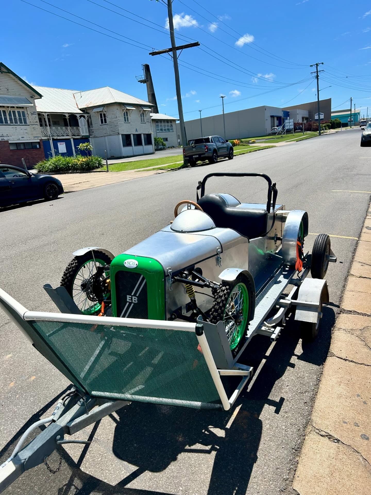 Vintage silver car with green accents on a trailer parked on a street— Bundaberg Radiator Service in Bundaberg East, QLD