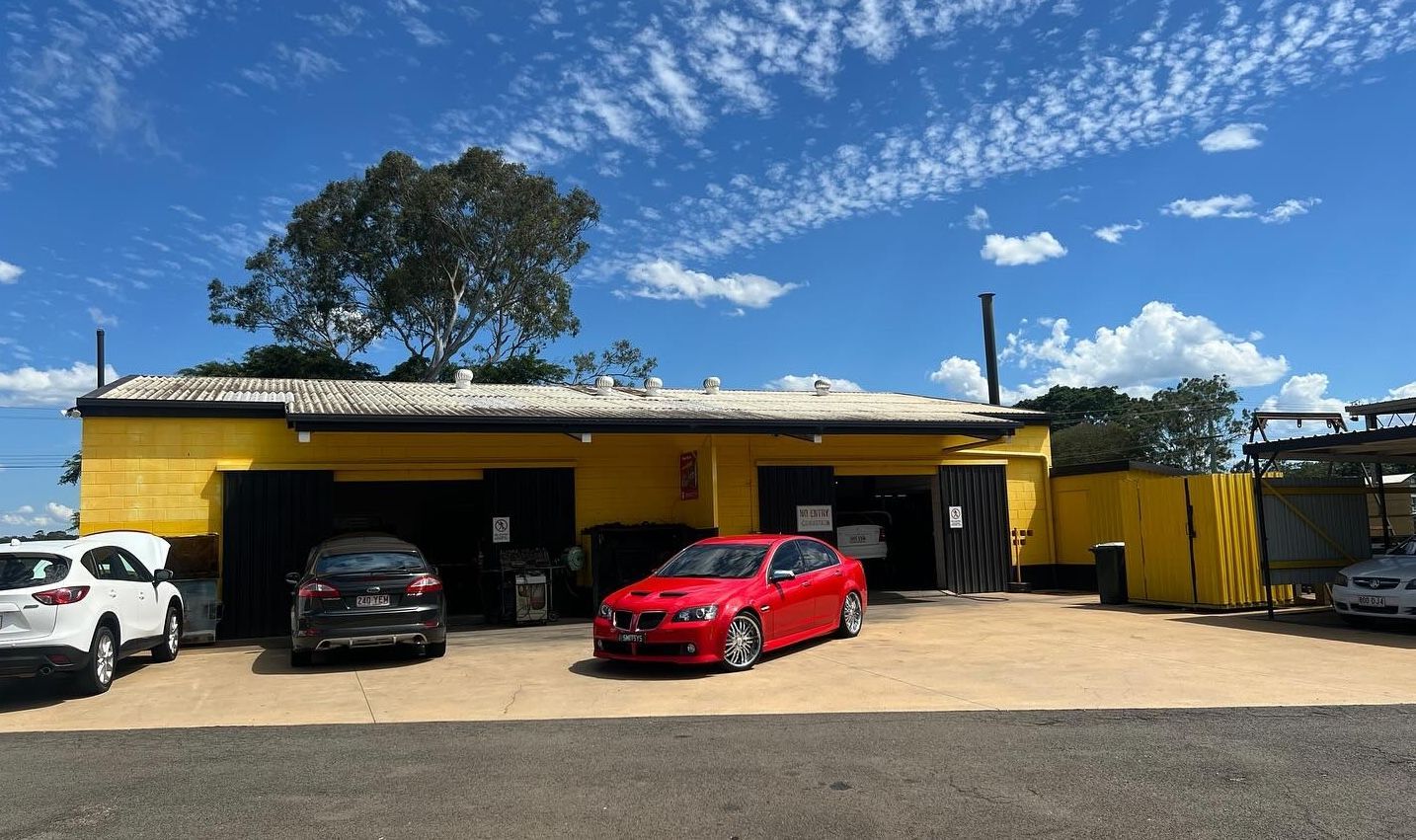 Hand inspecting car coolant reservoir in an engine bay.