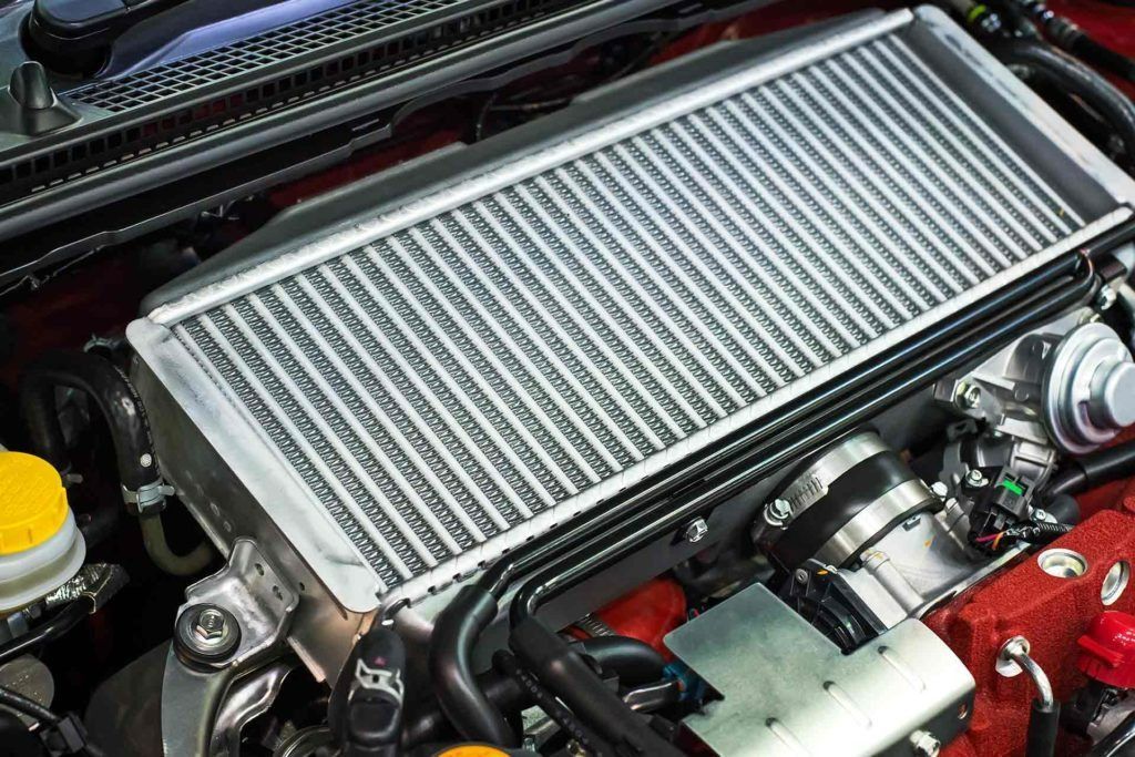 Intercooler installed on a car engine, silver radiator-like structure.