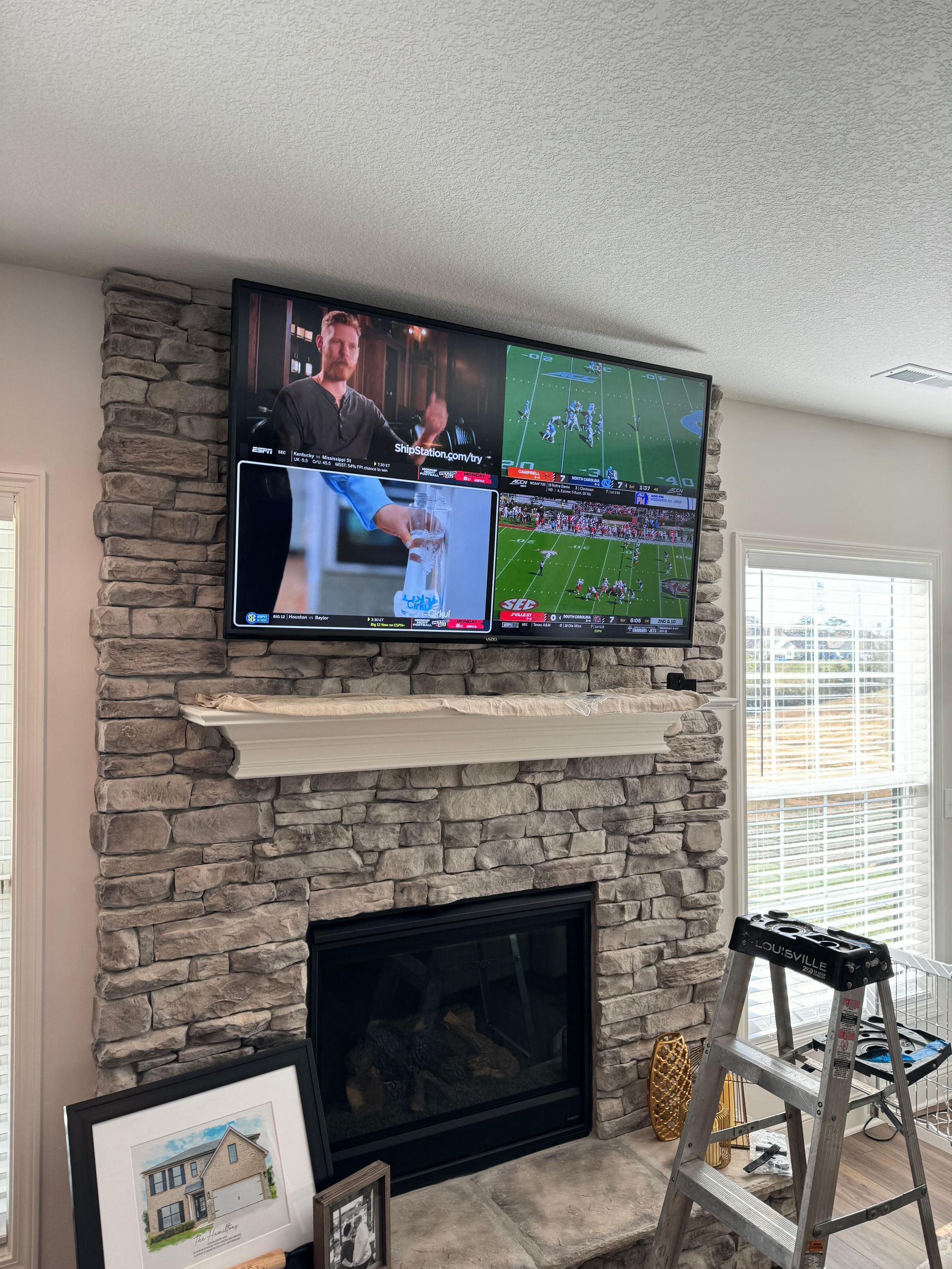 A living room with a fireplace and a flat screen tv mounted to the wall.