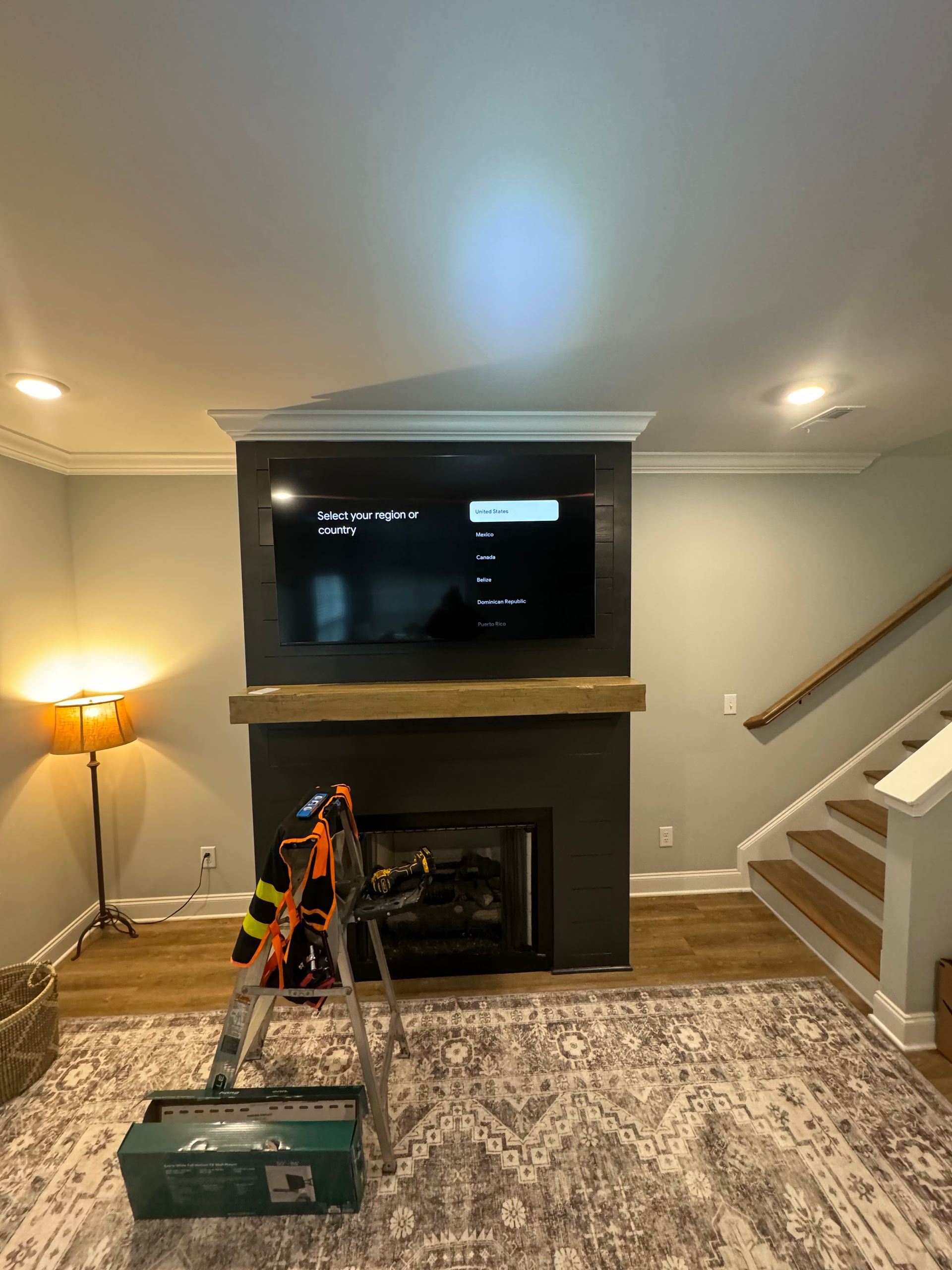 A living room with a fireplace and a flat screen tv mounted to the wall.