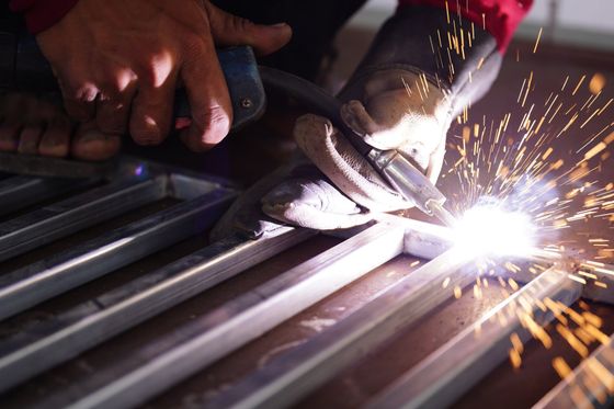 A fabricator builds a custom railing out of light metal.